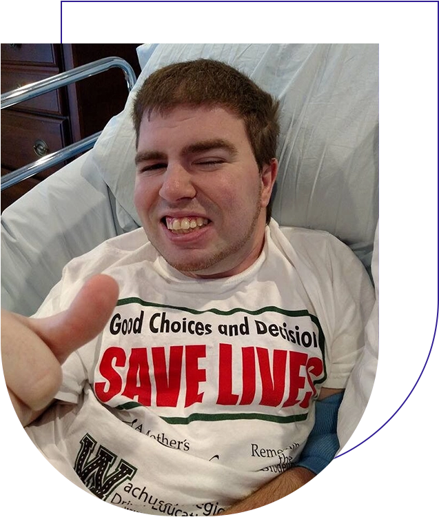 A man in a hospital bed with his thumb up.